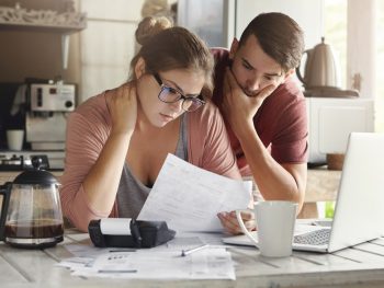 A couple reviewing their budget and stressing over money