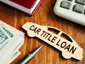 Money next to a calculator and a small wood car labeled ‘car title loan